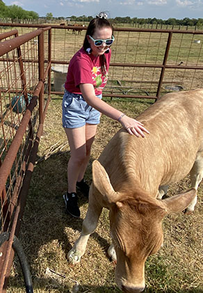 Rachel McNeal standing outside with cattle